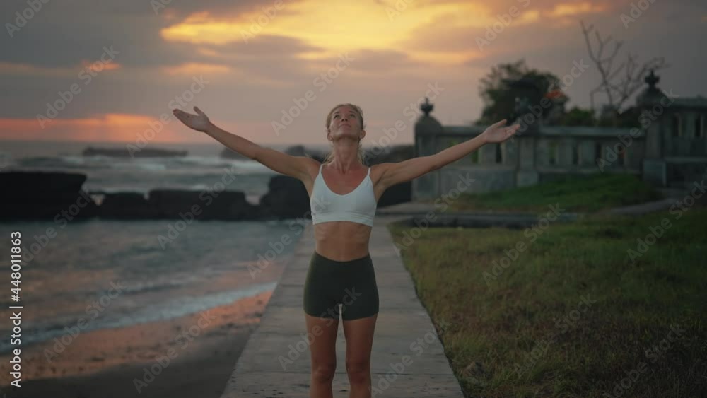 Woman lifting hands together in namaste yoga standing pose, sun salutation Woman lifting hands together in namaste yoga standing pose, sun salutation