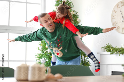 Fototapeta Naklejka Na Ścianę i Meble -  Happy daughter and father having fun at home on Christmas eve