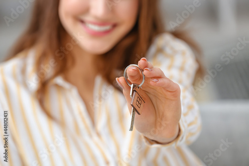 Happy young woman with key ...