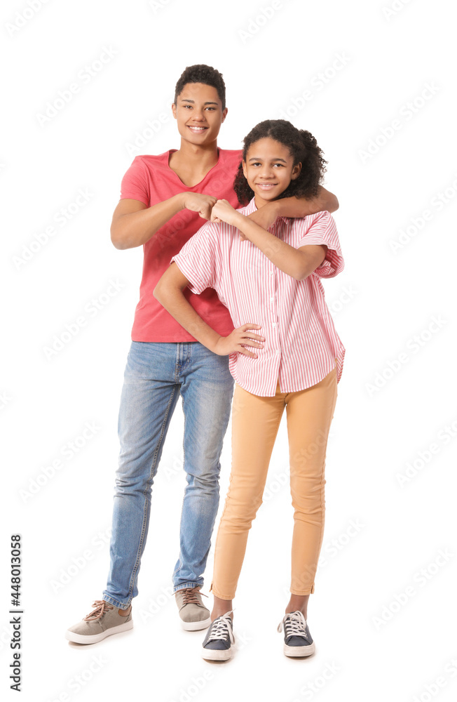 African-American brother and sister bumping fists on white background African-American brother and sister bumping fists on white background