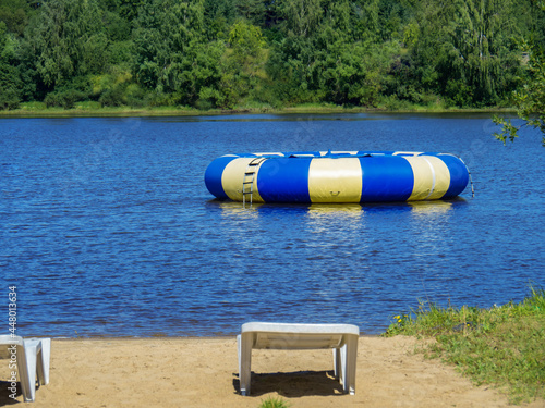 Large inflatable round blue trampoline on a pond