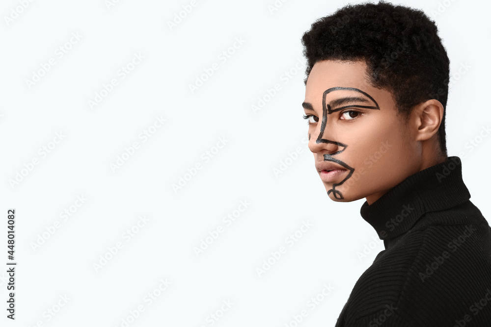 Obraz premium Young African-American guy with paint on face against light background