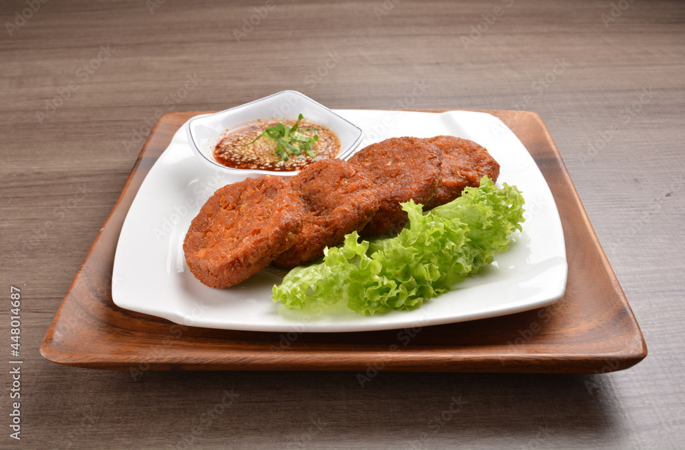 deep fried hash brown round potato cake with Thai spicy chilli sauce on wood background asian halal vegan menu deep fried hash brown round potato cake with Thai spicy chilli sauce on wood background asian halal vegan menu