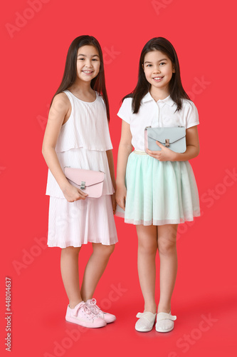 Cute Asian sisters with bag...