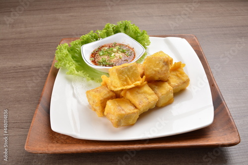 deep fried bean curd tofu with Thai spicy chilli sauce on wood background asian halal vegan menu