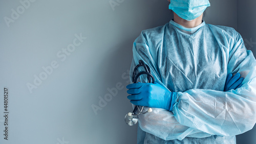 Medical worker portrait without face dressed in disposable medical gown and protective mask photo