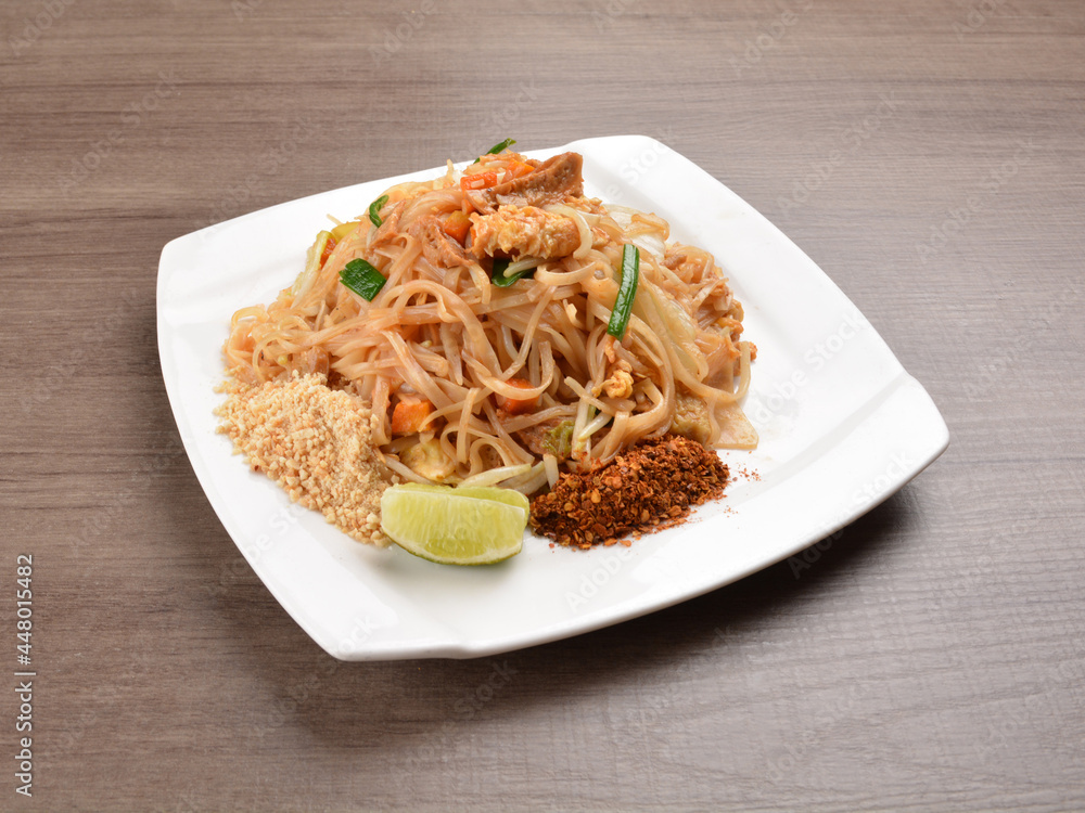 wok stir fried kway teow rice noodle mee goreng with vegetable in spicy soy chilli sauce on wood background asian halal vegan menu wok stir fried kway teow rice noodle mee goreng with vegetable in spicy soy chilli sauce on wood background asian halal vegan menu