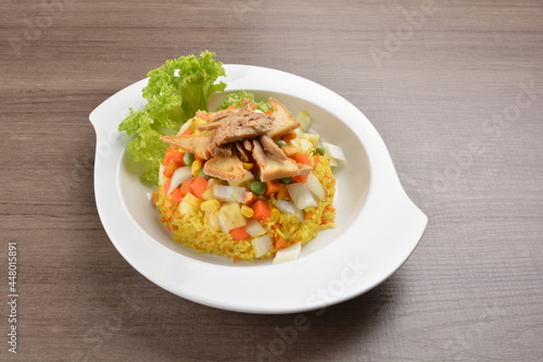 vegetarian nasi goreng fried rice with pineapple, vegetables meat in spicy chilli sambal sauce on wood background asian halal vegan menu