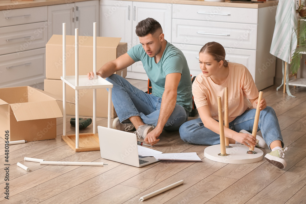 Young couple assembling furniture at home Young couple assembling furniture at home