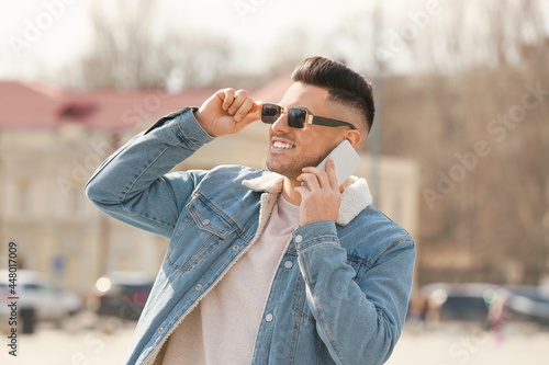 Young man talking by phone ...
