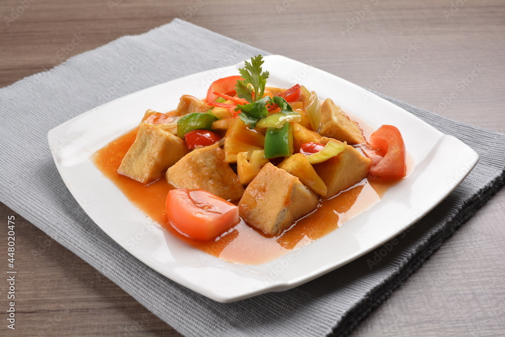 deep fried bean curd tofu with spicy sweet and sour chilli sauce on wood background asian halal vegan menu deep fried bean curd tofu with spicy sweet and sour chilli sauce on wood background asian halal vegan menu