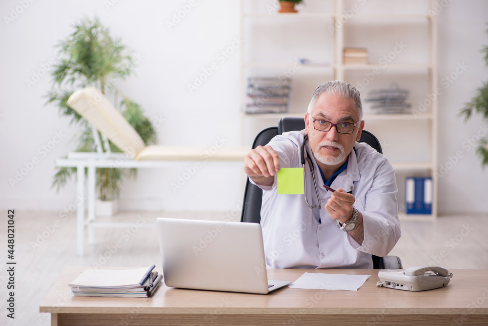 Old male doctor working in the clinic Old male doctor working in the clinic