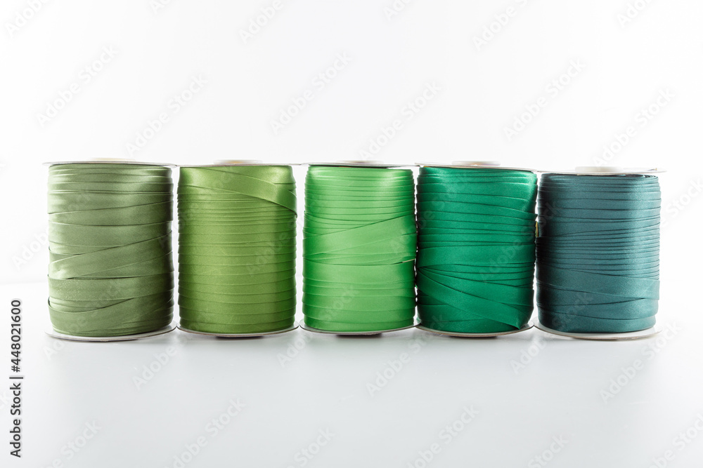 rolls with green decorative ribbons of different shades for clothes on a white background rolls with green decorative ribbons of different shades for clothes on a white background