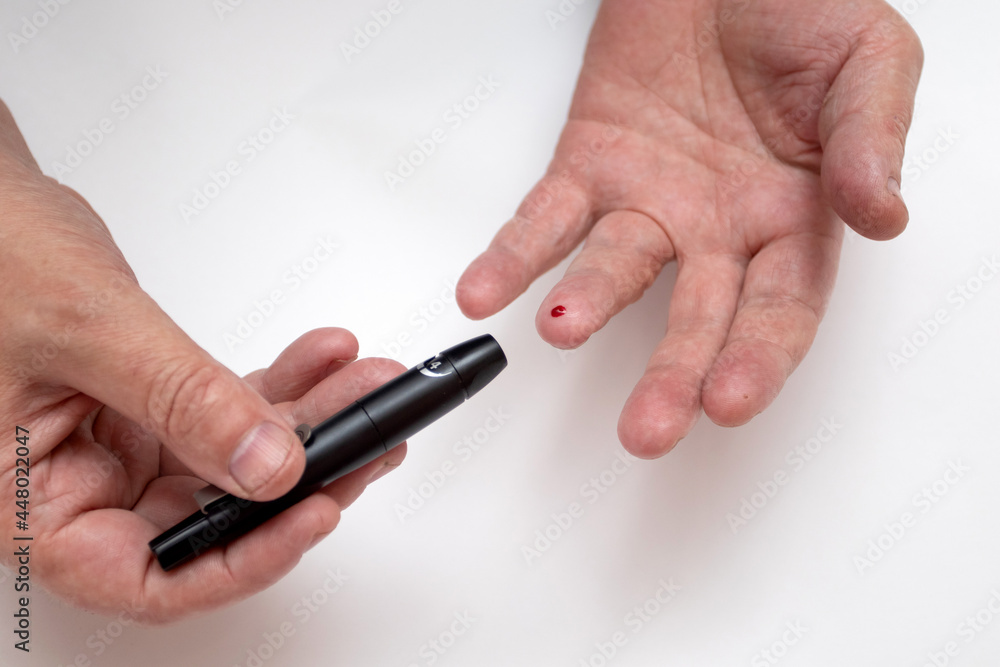 Man using glucometer on white background, top view Man using glucometer on white background, top view
