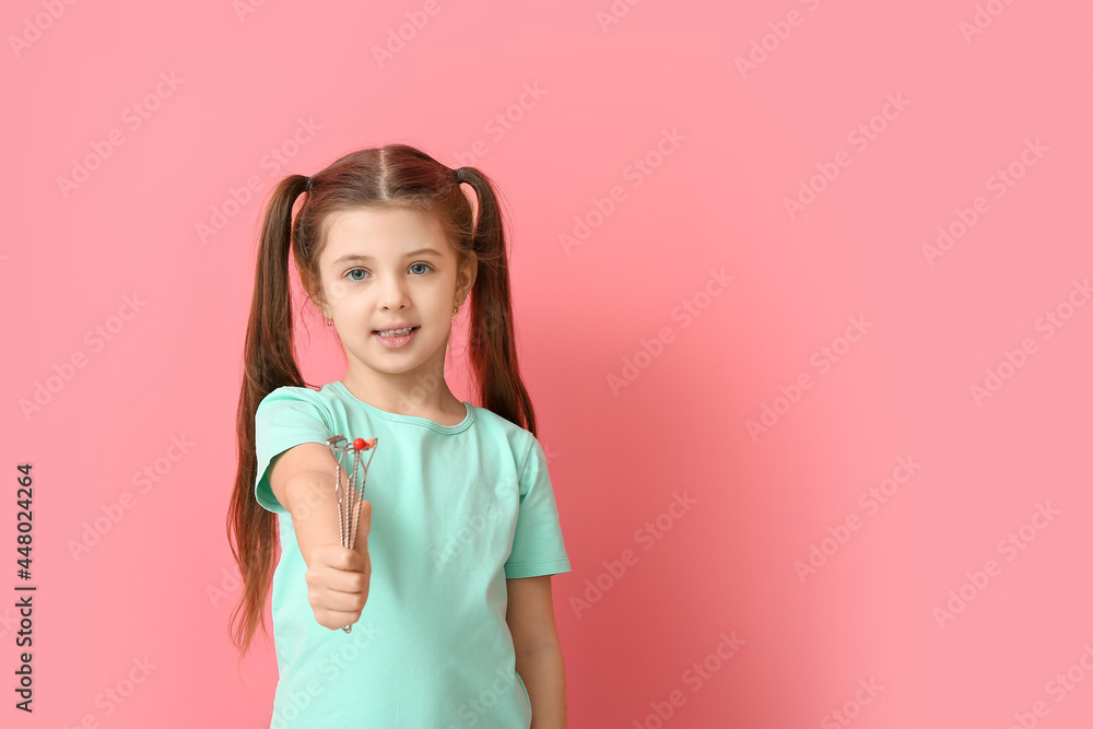 Little girl with logopedic tools for speech correction on color background Little girl with logopedic tools for speech correction on color background