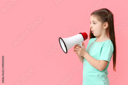 Little girl with megaphone training pronounce letters on color background