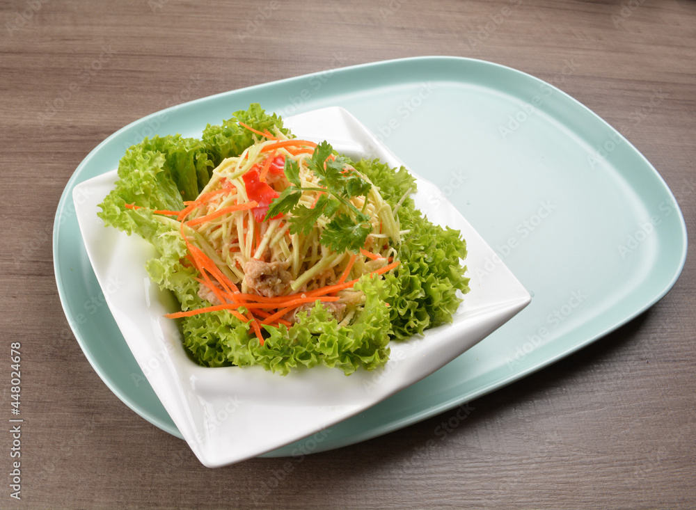 thai cold mango papaya vegetable salad in spicy sour lime sauce on wood background asian halal vegan menu thai cold mango papaya vegetable salad in spicy sour lime sauce on wood background asian halal vegan menu
