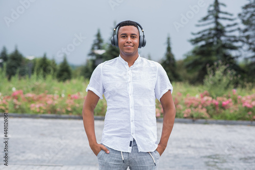 Portrait of a young and happy African American man with headphones. Person listening to music