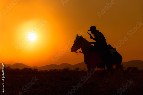 Fototapeta Naklejka Na Ścianę i Meble -  Cowboy silhouette riding a horse When the sunset looks beautiful
