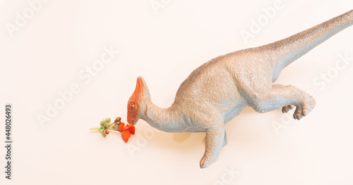 Modern arrangement of hungry dinosaur eating red flower