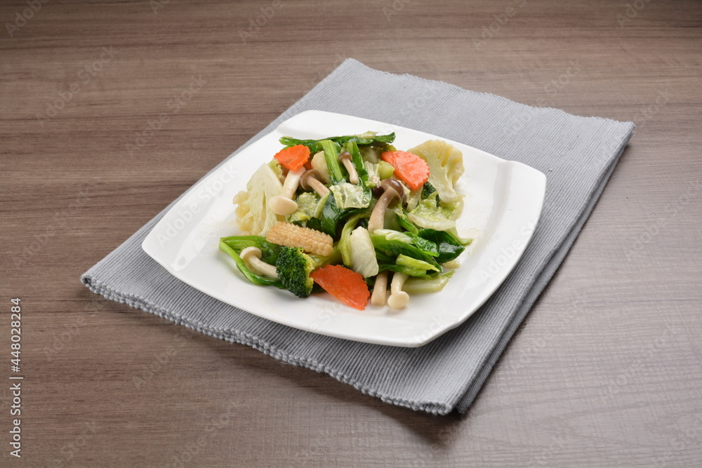 stir fried mixed vegetable and carrot in soy sauce on wood background asian halal vegan menu stir fried mixed vegetable and carrot in soy sauce on wood background asian halal vegan menu