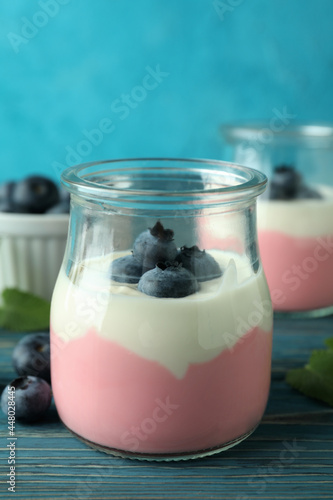 Concept of tasty breakfast with yogurt on wooden table