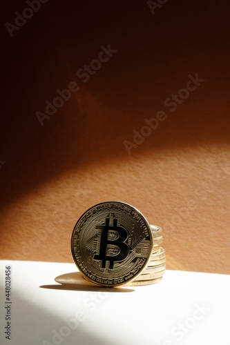 Crypto currency. Bitcoin physical coin on yellow background.