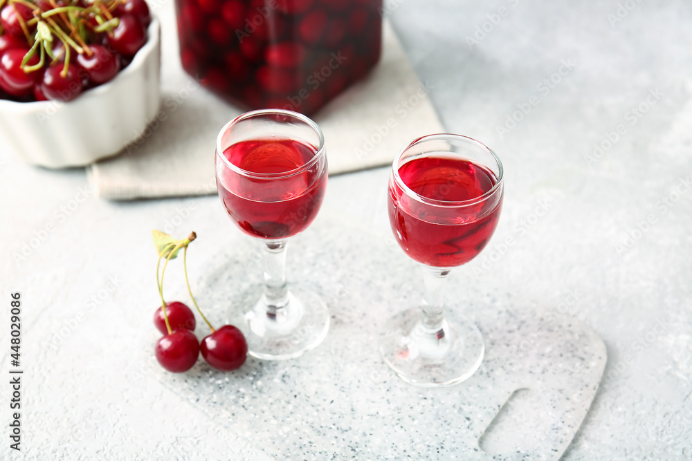 Glasses of sweet cherry wine on light background Glasses of sweet cherry wine on light background