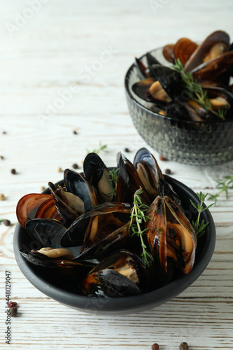 Bowls with fresh mussels on white wooden table