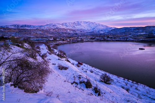 Beautiful winter morning landscape at Lake Ram or Birkat el-Ram, a crater lake (maar) in the northeastern Golan Heights, Israel, surrounded by snow-covered hills photo