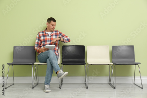 Man with tablet waiting for job interview indoors © New Africa