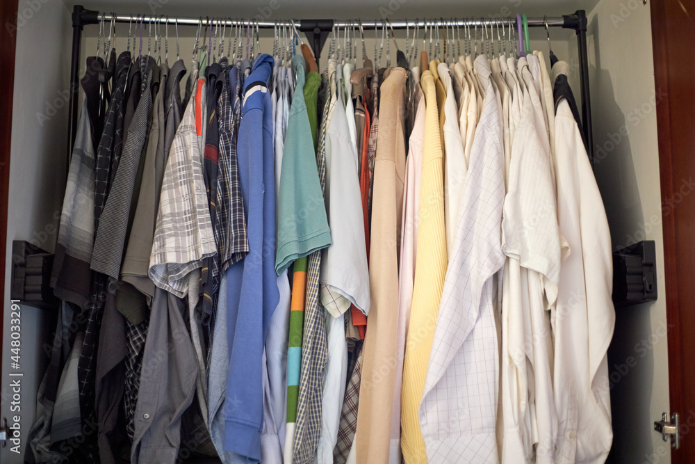 A rack of second hand clothes in an old closet, unused and ready to be resold, up for a bargain A rack of second hand clothes in an old closet, unused and ready to be resold, up for a bargain