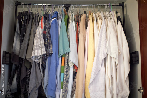 A rack of second hand clothes in an old closet, unused and ready to be resold, up for a bargain