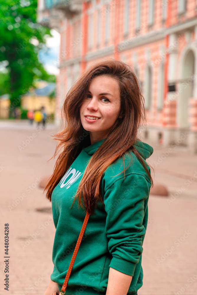 Portrait of a young brunette woman on a city street
