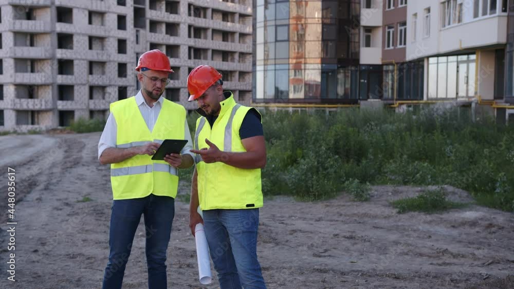 Two engineers using a black tablet in the house building