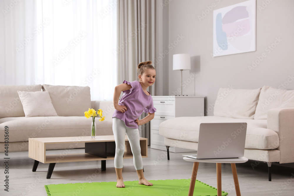 Cute little girl warming up before online dance class at home Cute little girl warming up before online dance class at home