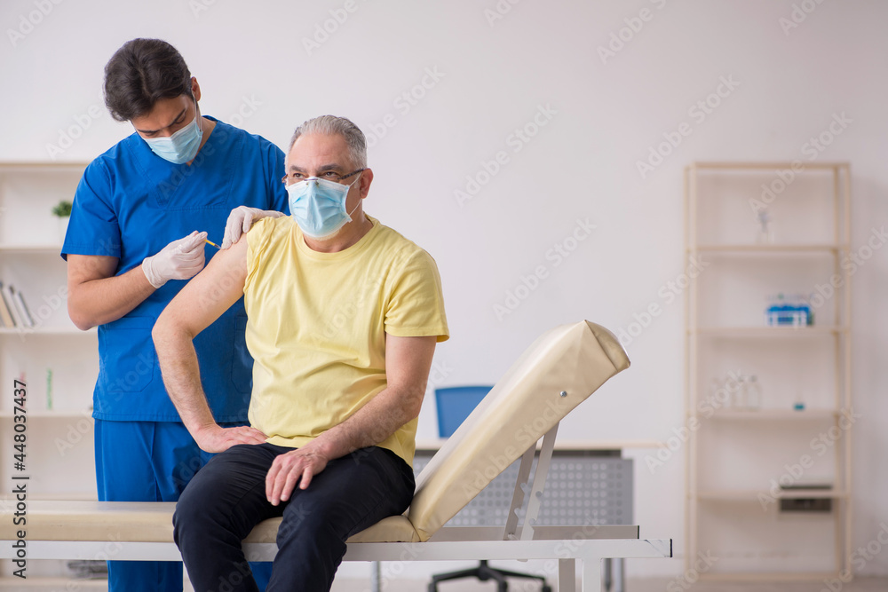 Old male patient visting young male doctor in vaccination concep Old male patient visting young male doctor in vaccination concep