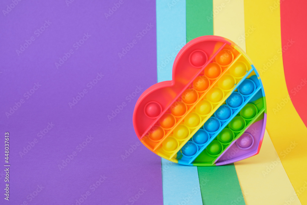 colorful antistress sensory toy fidget push pop it on rainbow background - obrazy, fototapety, plakaty 