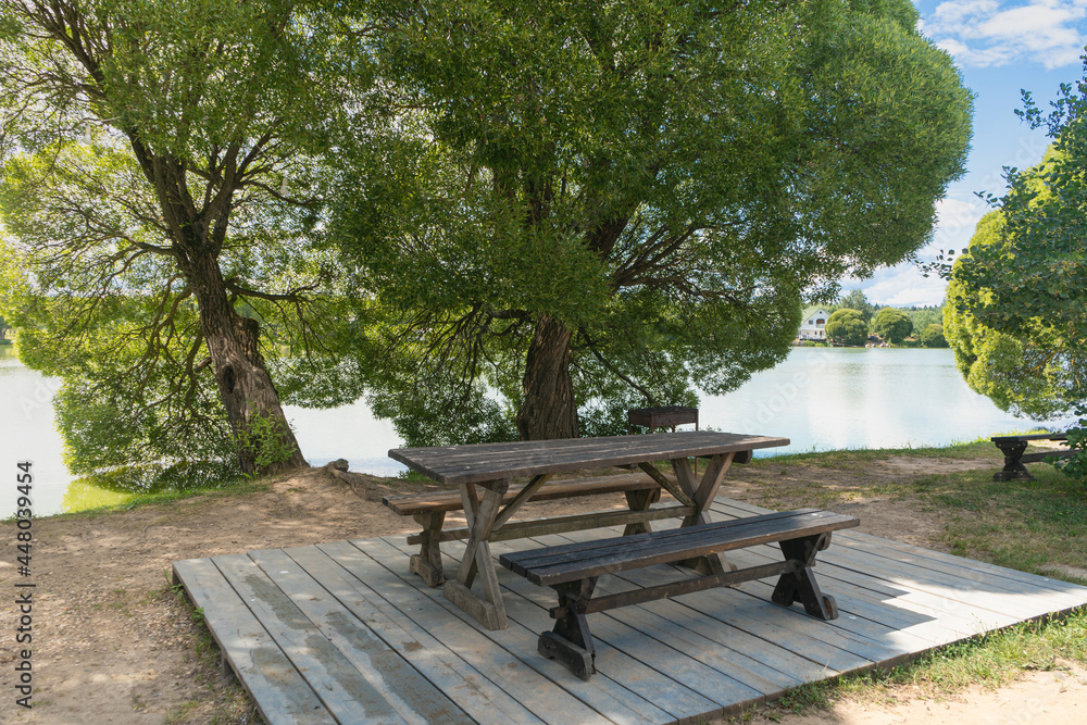 Empty picnic bench by the roadside next to the pond. tourism concept Empty picnic bench by the roadside next to the pond. tourism concept
