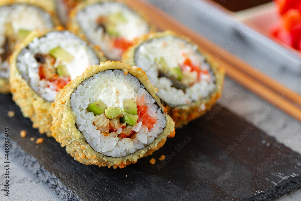 Japanese sushi tempura roll served on black stone plate Japanese sushi tempura roll served on black stone plate