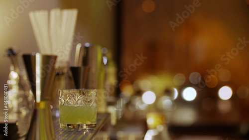 Fototapeta Naklejka Na Ścianę i Meble -  Fresh glass of tropical cocktail with juice at bar counter background.