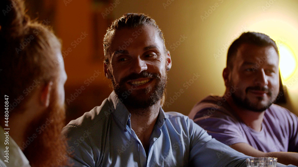 Obraz premium Happy male friends meet in bar, talk and relax