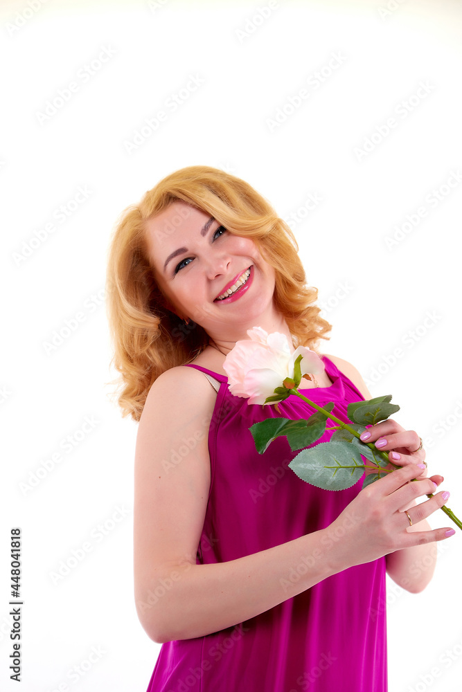 Happy beautiful woman with long blond curly hair and in elegant dress posing with rose flower in studio on white background Happy beautiful woman with long blond curly hair and in elegant dress posing with rose flower in studio on white background
