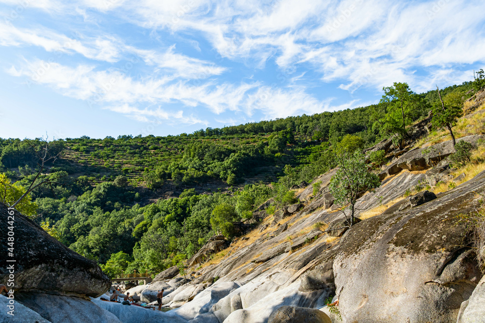 Río en paisaje de montaña con cielo azul y nubes