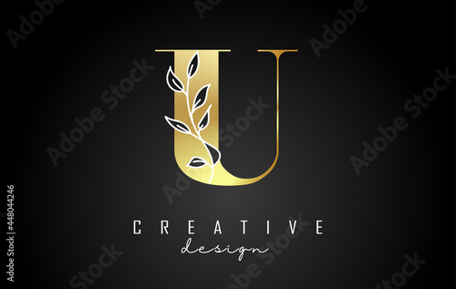 Golden U letter logo design with white leaves branch vector illustration.