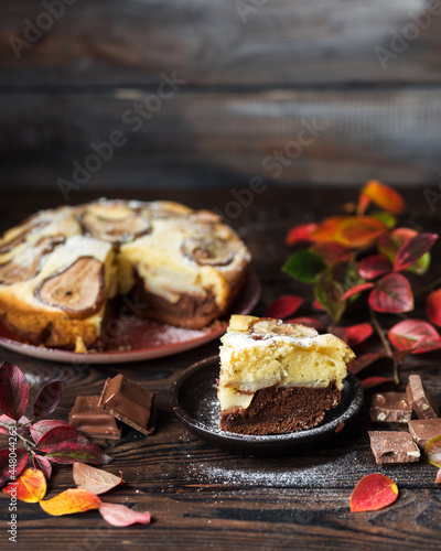 Autumn chocolate cake with cinnamon and spices. Still life of October yellow leaves on a wooden table. Homemade chocolate pastries . Autumn still life  chocolate pie with pear