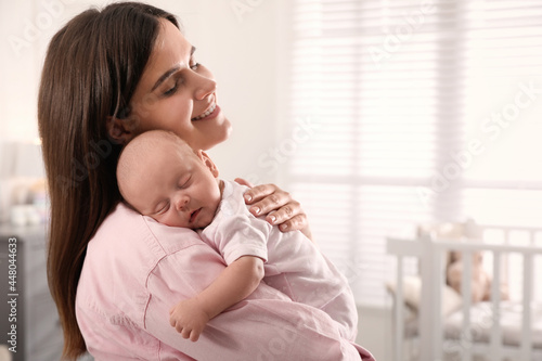 Young woman with her little baby at home. Space for text