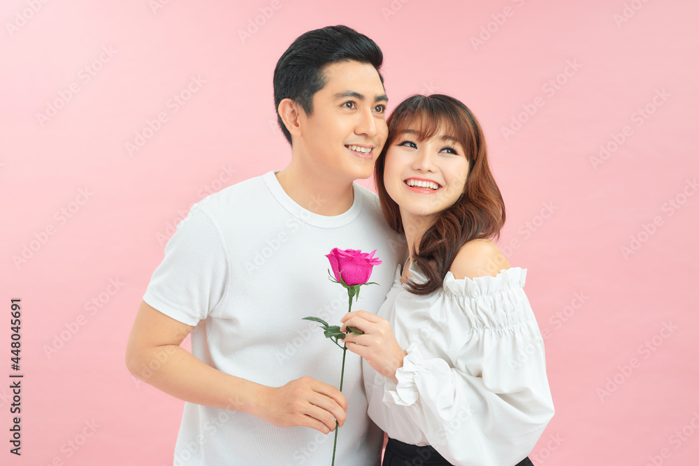 Lovely couple holding flower on pink background Lovely couple holding flower on pink background