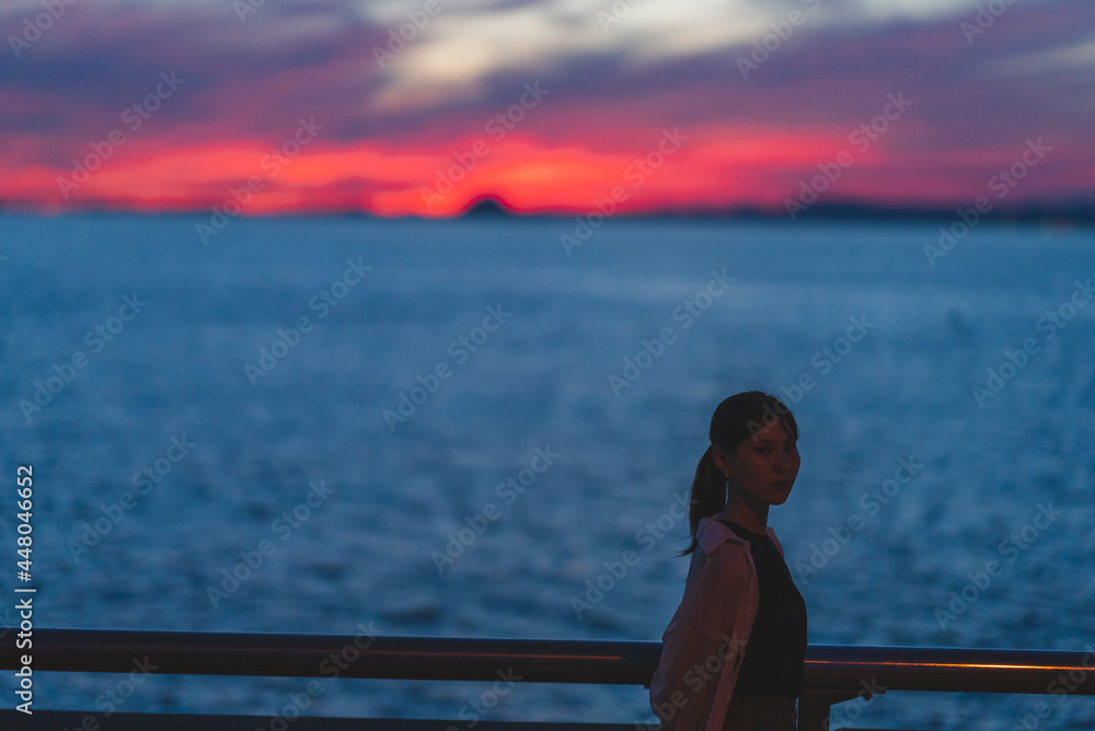 夕暮れの海にいる女性