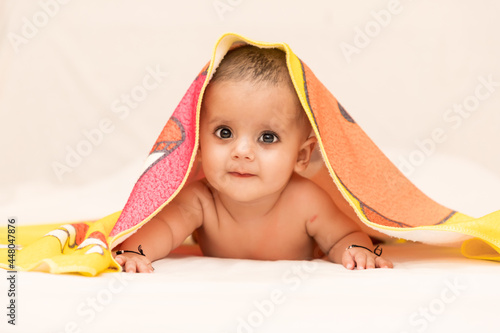 close up photo shoot of a indian baby girl covered with blanket.